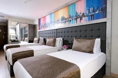 two beds in a hotel room with a painting on the wall at Four Sides Sisli in Istanbul