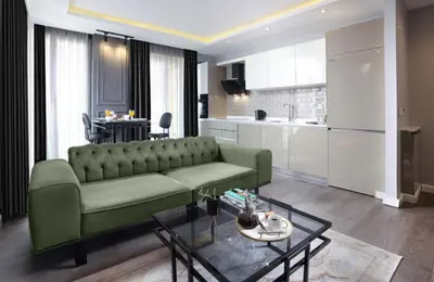 a living room with a green couch and a table at Ataşehir The Place Suites in Istanbul