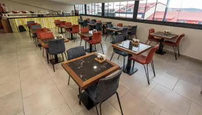 an empty dining room with tables and chairs at Istanbul Airport Express Hotel in Arnavutköy