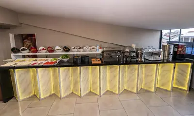 a kitchen with a counter with food on it at Istanbul Airport Express Hotel in Arnavutköy