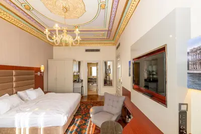 a bedroom with a bed and a tv and a chair at Blue Gilroy Hotel in Istanbul