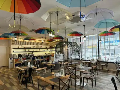 a restaurant with tables and umbrellas hanging from the ceiling at Tempo Suites Airport in Istanbul
