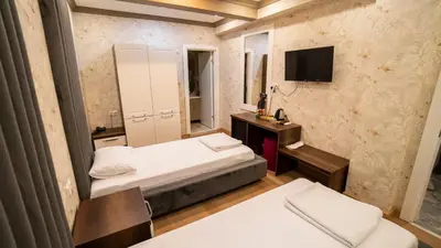 a small room with two beds and a television at DYMAR HOTEL in Istanbul