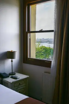 a bedroom with a window and a table with a lamp at Galata Dream Hotel in Istanbul