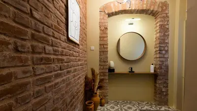 a bathroom with a brick wall and a mirror at Maravilloso Hotel Pera in Istanbul