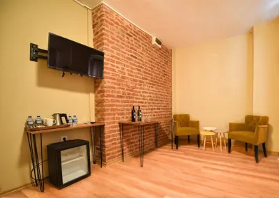 a living room with a tv and a brick wall at Maravilloso Hotel Pera in Istanbul
