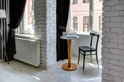 a table and a chair in a room with windows at Maravilloso Hotel Galata in Istanbul