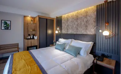 a bedroom with a large bed with two blue pillows at Kayhan City Hotel in Bursa