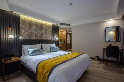 a bedroom with a large bed with a yellow blanket at Kayhan City Hotel in Bursa