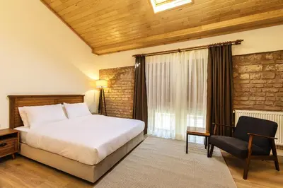 a bedroom with a bed and a chair and a window at The Nomad Inn Old City İstanbul in Istanbul