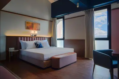 a hotel room with a bed and a chair and window at Four Points Flex by Sheraton Bursa Nilüfer in Bursa