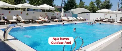 a pool with chairs and people in the water at Yalova Lova Hotel & SPA Yalova in Yalova