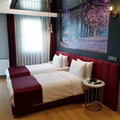 two beds in a hotel room with a painting on the wall at My Garden Hotel in Istanbul