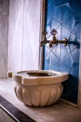 a water fountain in a bathroom with blue tiles at Thermal Saray Hotel & Yalova in Gokcedere