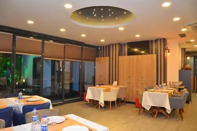 a restaurant with tables and chairs in a room at Otel Grand Lark İstanbul in Istanbul