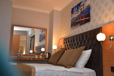 a bedroom with a large bed and a large mirror at Otel Grand Lark İstanbul in Istanbul