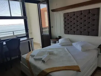 a bedroom with a bed with a desk and a window at Blue Pier Hotel in Kocaeli