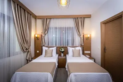 two beds in a hotel room with a window at Zeyn Otel Istanbul in Istanbul