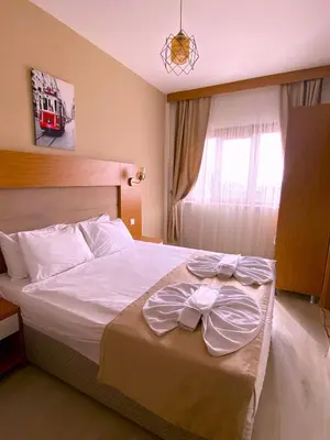 a bedroom with a bed with white sheets and a window at Zeyn Otel Istanbul in Istanbul