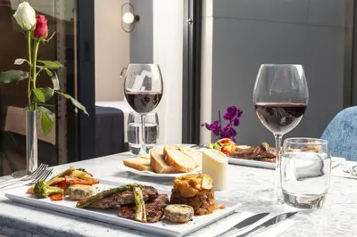 a table with two plates of food and wine glasses at GRANBELLAHOTEL in Tekirdag