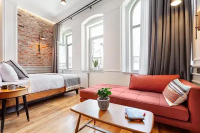a living room with a red couch and a bed at World House Boutique Hotel Galata in Istanbul