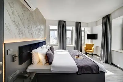 a hotel room with a large bed and a chair at Taksim Seya Suites Hotel in Istanbul