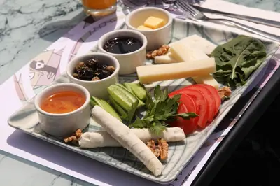 a tray of food with cheese and vegetables on a table at Taksim Seya Suites Hotel in Istanbul