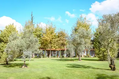 a field with trees in front of a building at The Lake House in Boyalıca
