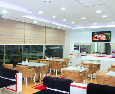 a restaurant with tables and chairs and a tv at Avcılar İnci Hotel in Istanbul