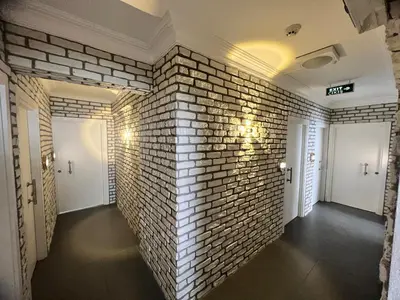 a room with a brick wall and two white doors at Karaca Suite in Tuzla