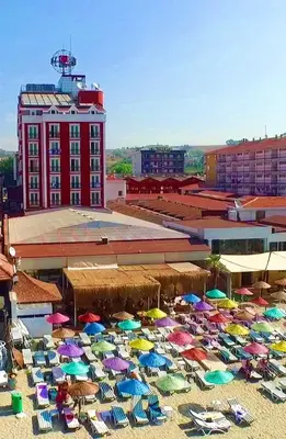 a bunch of umbrellas and chairs on a beach at Kumburgaz Blue World Hotel in Buyukcekmece