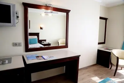 a room with a mirror and a desk with a mirror at Kumburgaz Blue World Hotel in Buyukcekmece