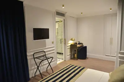 a room with a chair and a television on a wall at A11 HOTEL Exclusive in Istanbul