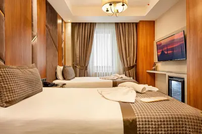 a hotel room with two beds and a tv at Santra Hotel in Istanbul