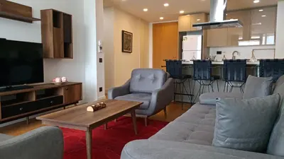 a living room with a couch and a tv and a table at Prime Istanbul Residences in Istanbul