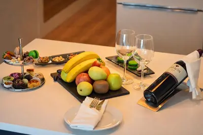 a table with a plate of fruit and wine glasses at Prime Istanbul Residences in Istanbul
