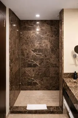 a shower in a bathroom with a stone wall at Prime Istanbul Residences in Istanbul