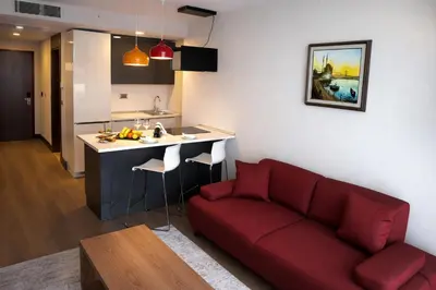 a living room with a red couch and a kitchen at Prime Istanbul Residences in Istanbul
