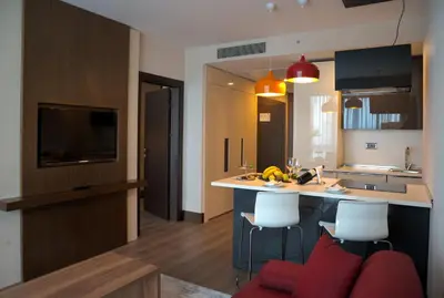 a kitchen with a kitchen island with a red couch at Prime Istanbul Residences in Istanbul