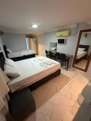 a bedroom with a large bed and a dining room at AWWA APART HOTEL in Istanbul