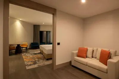 a room with a bed and a couch and a bedroom at Hilton Mall Of Istanbul in Istanbul