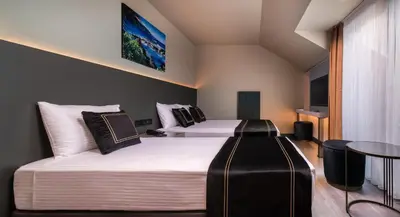 a hotel room with two beds and a table at MENALO HOTEL PREMIUM ISTANBUL AIRPORT in Istanbul