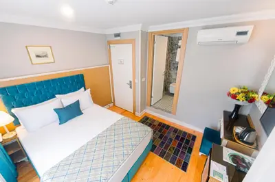 a hotel room with a bed and a mirror at Acacia Mansion Hotel in Istanbul