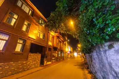 an empty street at night with buildings and a wall at Acacia Mansion Hotel in Istanbul