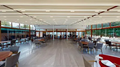 a dining room with tables and chairs and windows at DOUBLE ROYAL HOTEL in Kocaeli