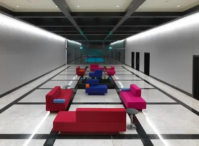a waiting area with red and blue chairs in a lobby at Workinn Hotel in Gebze