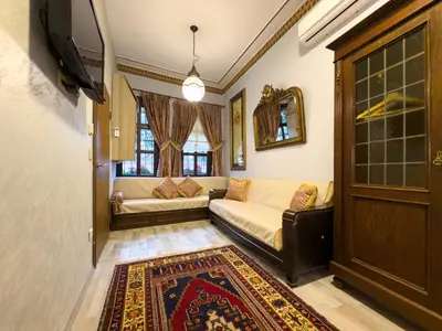 a living room with a couch and a tv at Antik Konak Little Hagia Sophia Suites in Istanbul