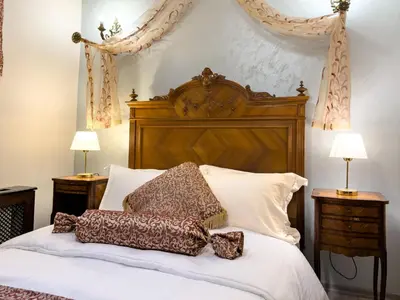 a bed with a wooden headboard and pillows on it at Antik Konak Little Hagia Sophia Suites in Istanbul