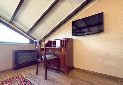 an attic room with a desk and a flat screen tv at Antik Konak Little Hagia Sophia Suites in Istanbul