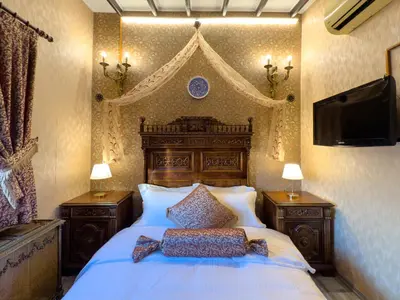 a bedroom with a large bed and a flat screen tv at Antik Konak Little Hagia Sophia Suites in Istanbul